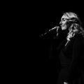 Celine Weerts zingt op het podium in een microfoon.