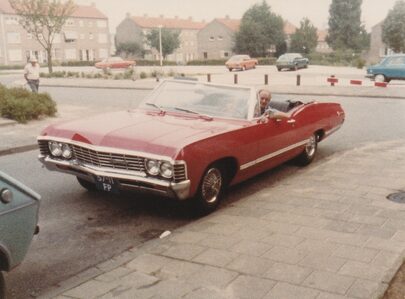 Oude familiefoto van Anno Mink in een rode Chevrolet.