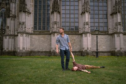 Een man sleept een andere man over de grond.