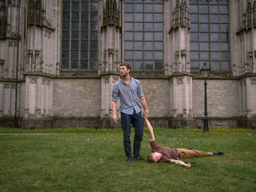 Een man sleept een andere man over de grond.